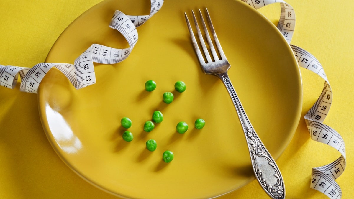 Diet yellow plate with centimeter peas and fork